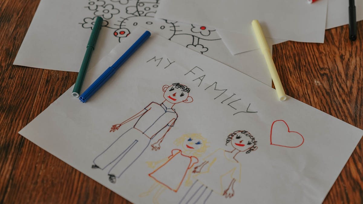 A hand-drawn family portrait using colored markers on paper, showcasing creativity and love.